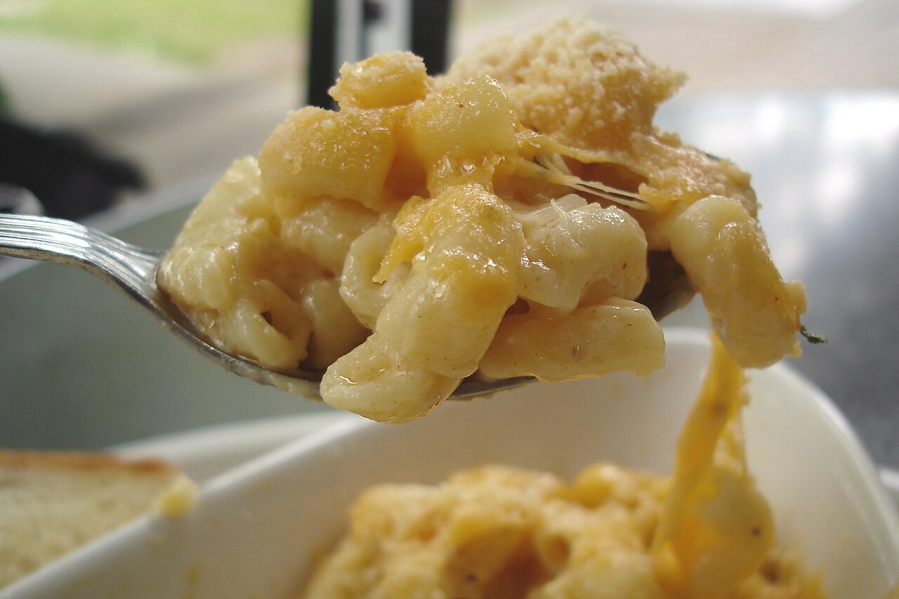 Sendok penuh mac and cheese dengan keju yang meleleh